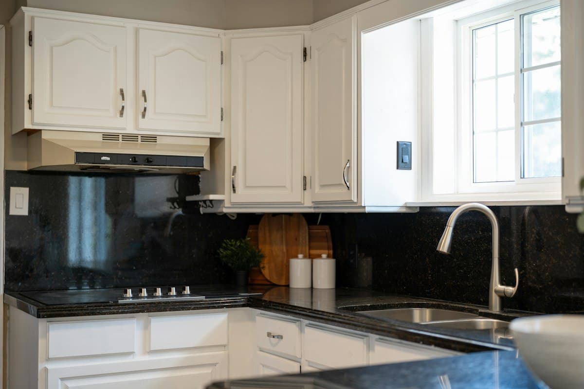 White painted cabinetry with dark countertops