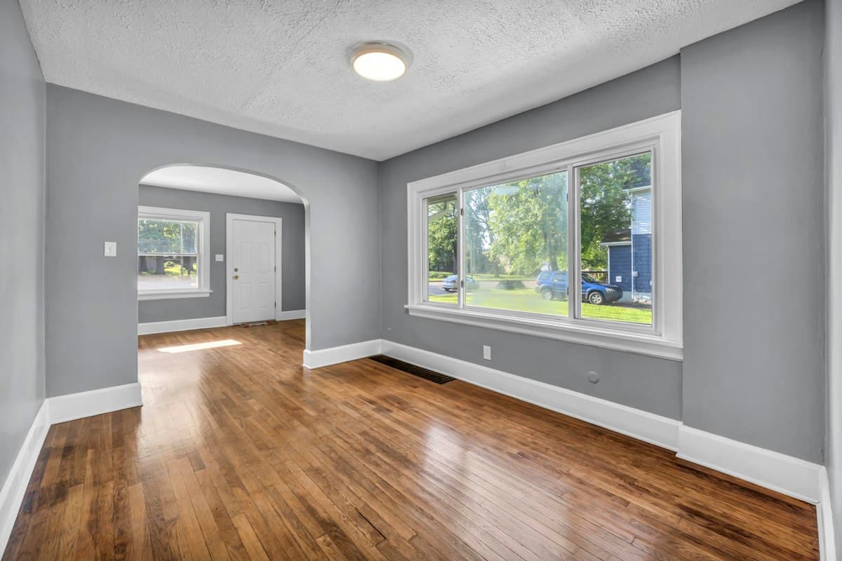 A freshly painted gray room with hardwood floors