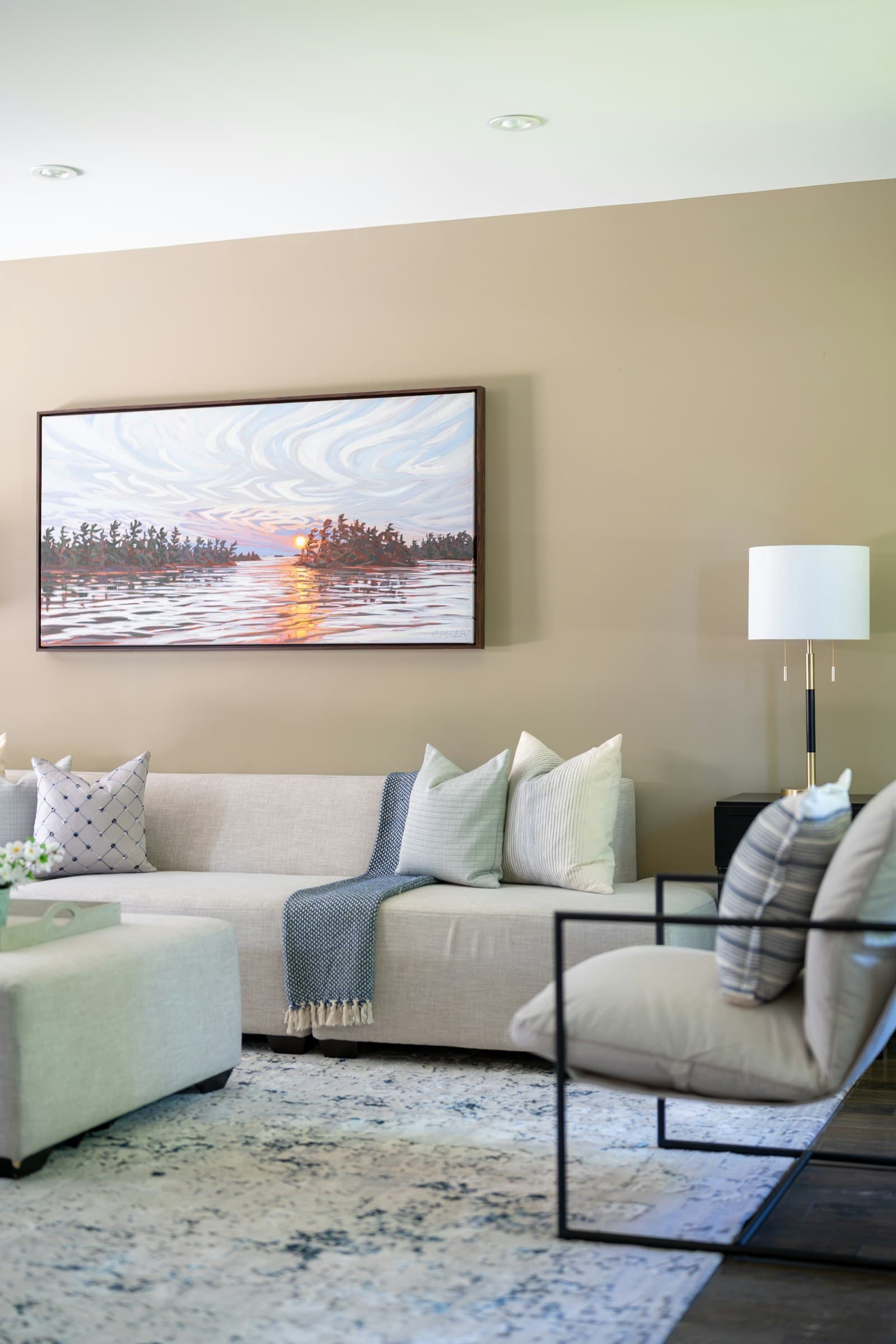 An elegant finished living room with warm painted walls, sofa and armchair