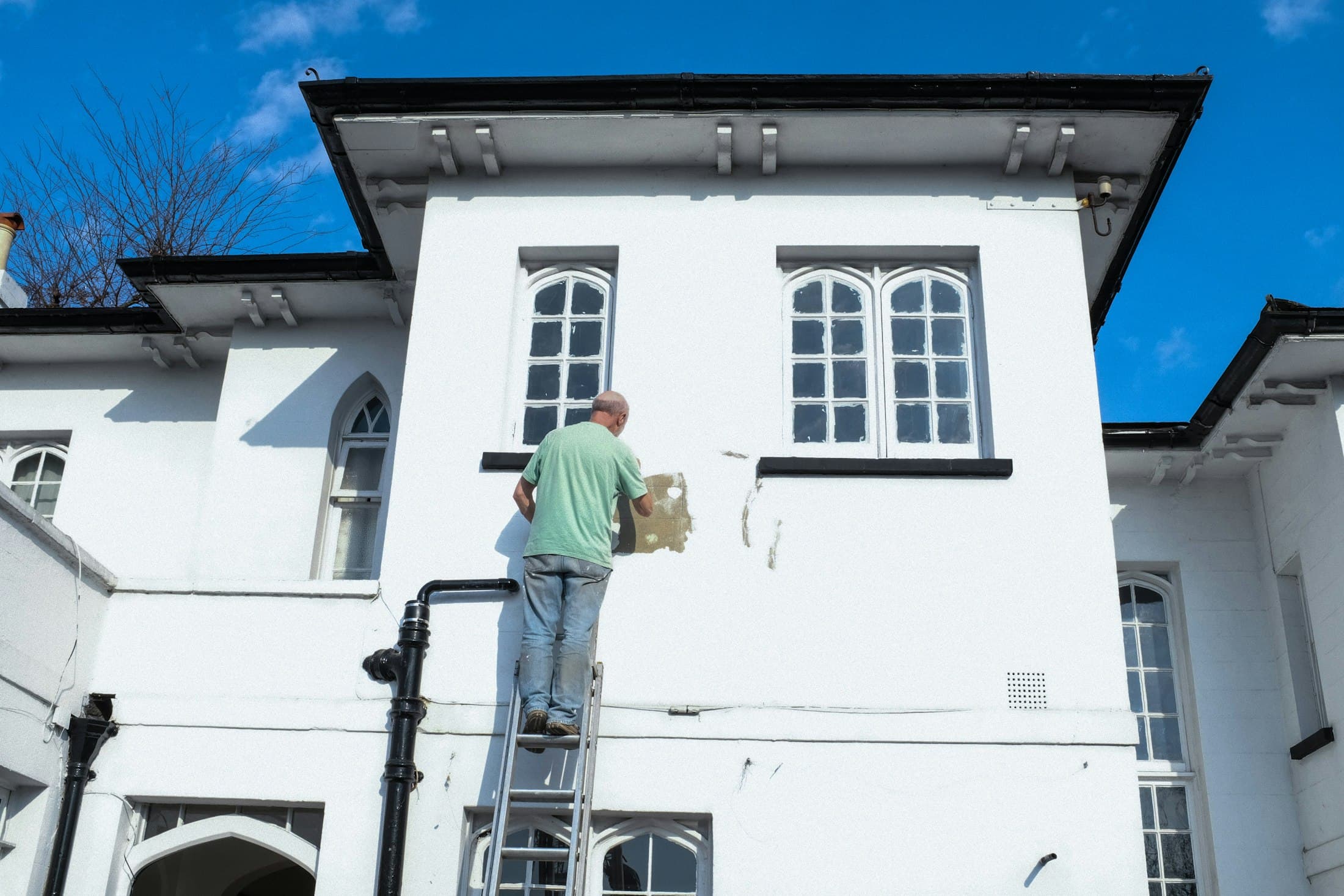 A painter carefully cutting in paint along an interior wall