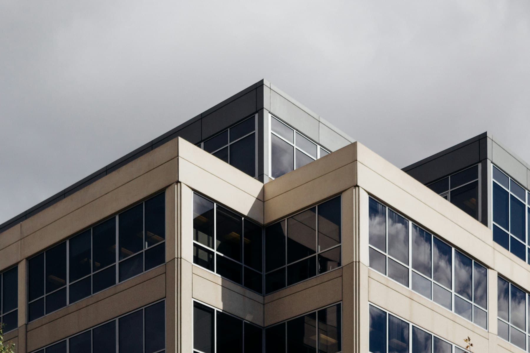 A tan commercial office building exterior corner against a blue sky